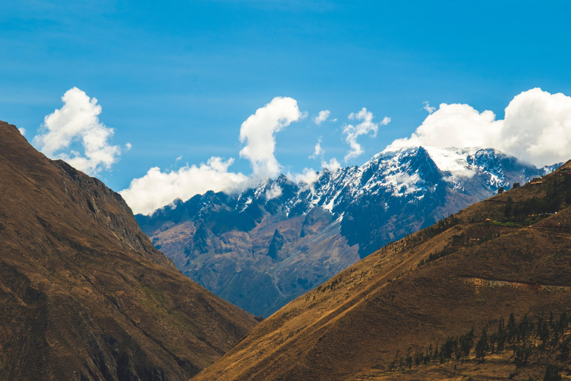 Snowy peaks rising between valley slopes