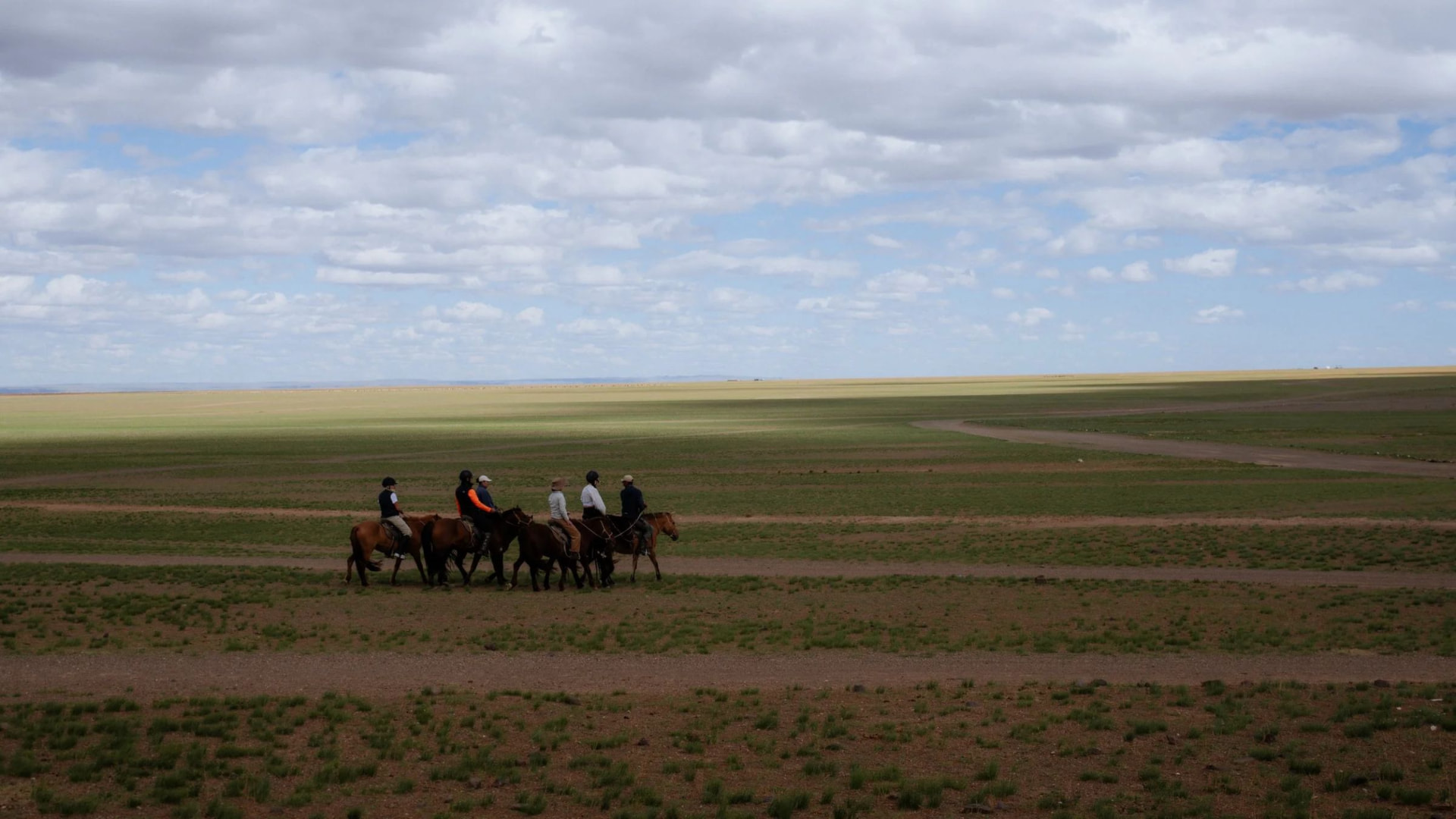 Riders crossing the open grasslands