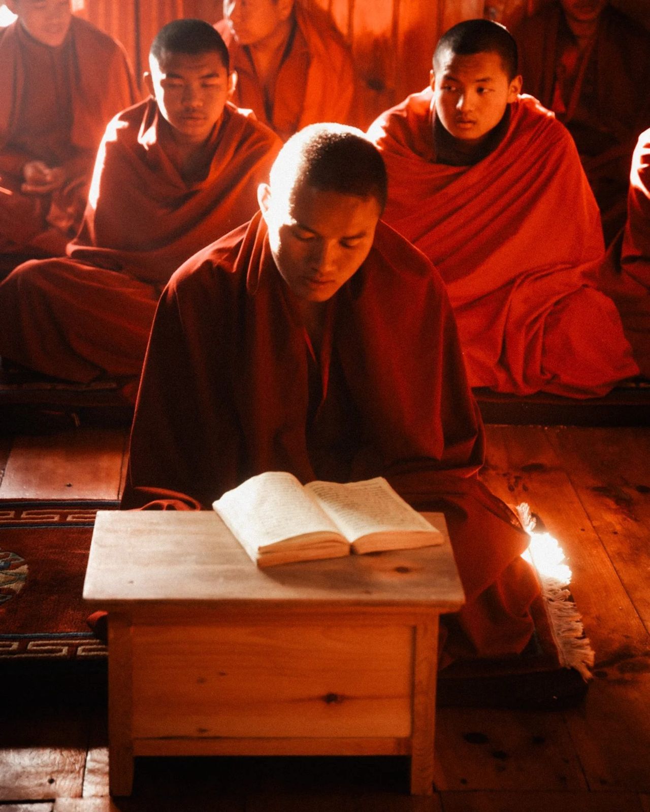 A young monk reading scripture in a Bhutanese temple