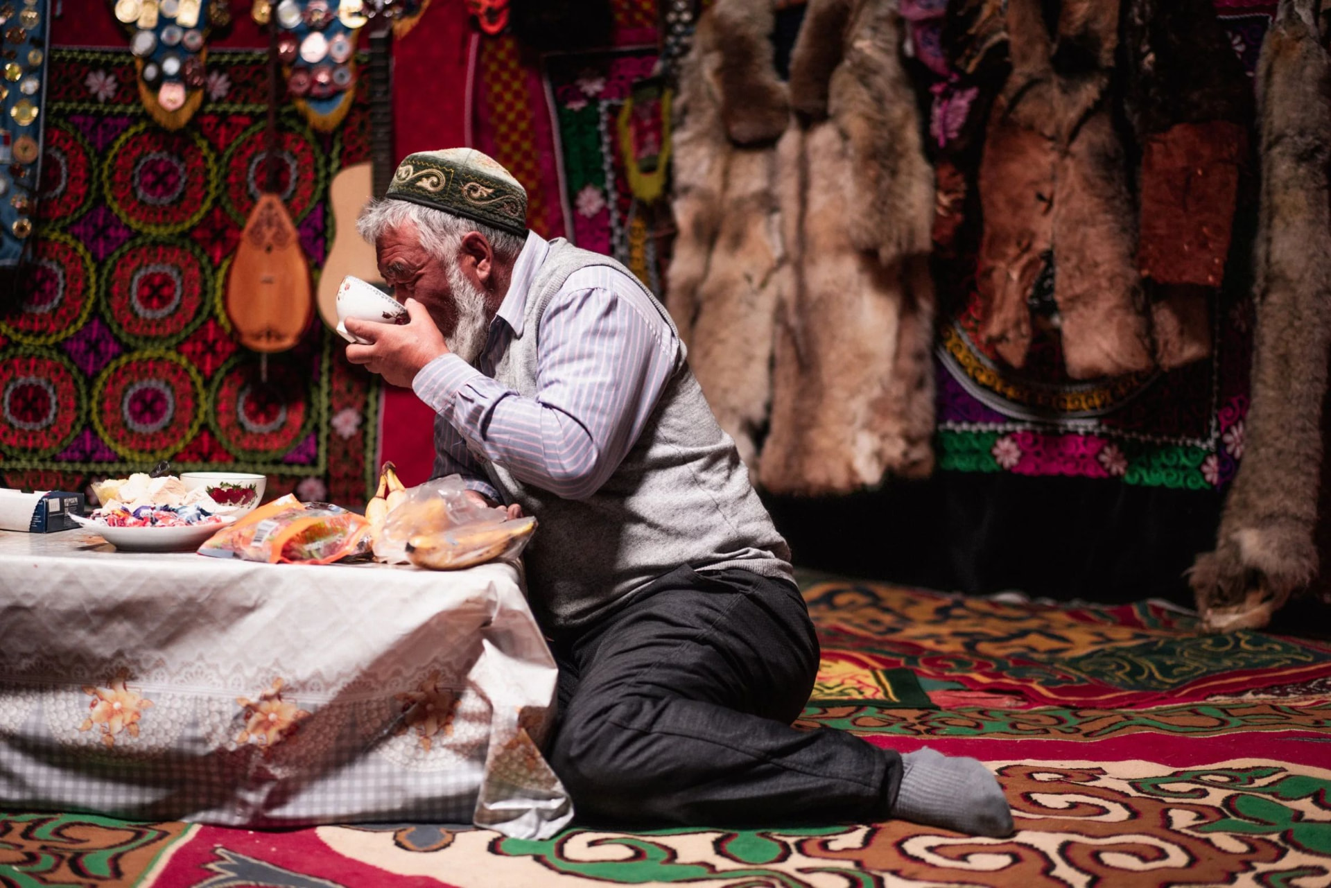 A man drinking tea inside a decorated ger