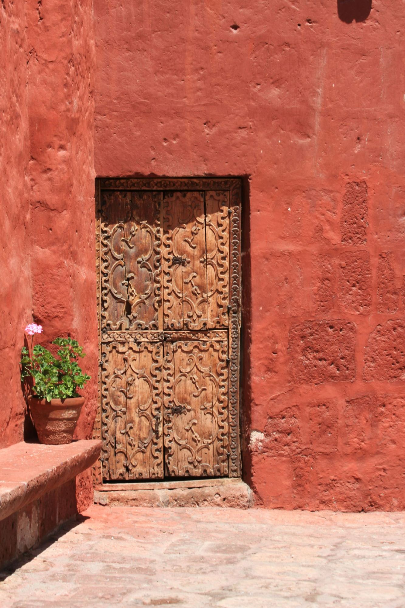A carved wooden door in a red wall