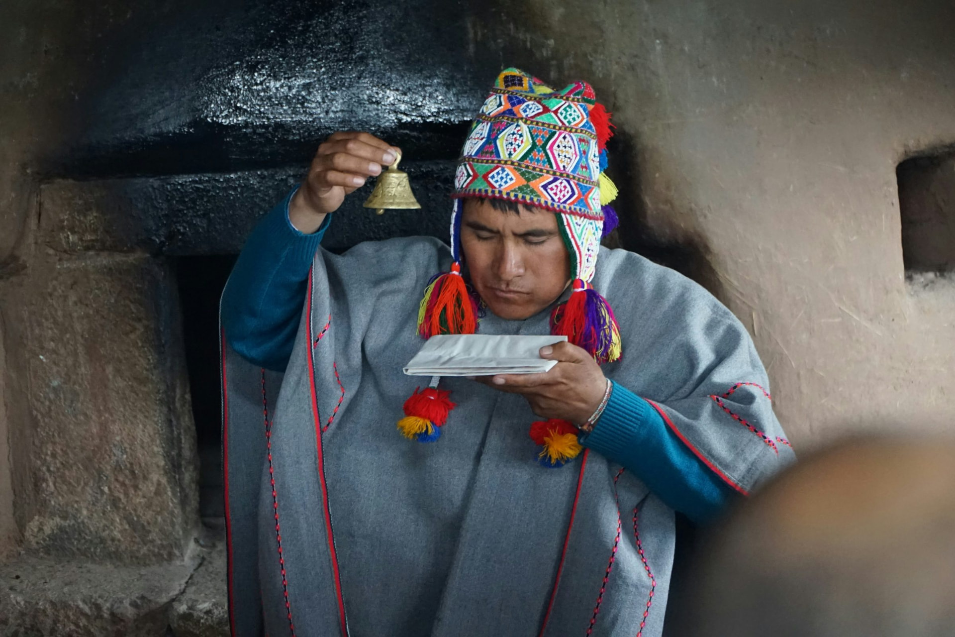 A paqo ringing a bell in ceremony