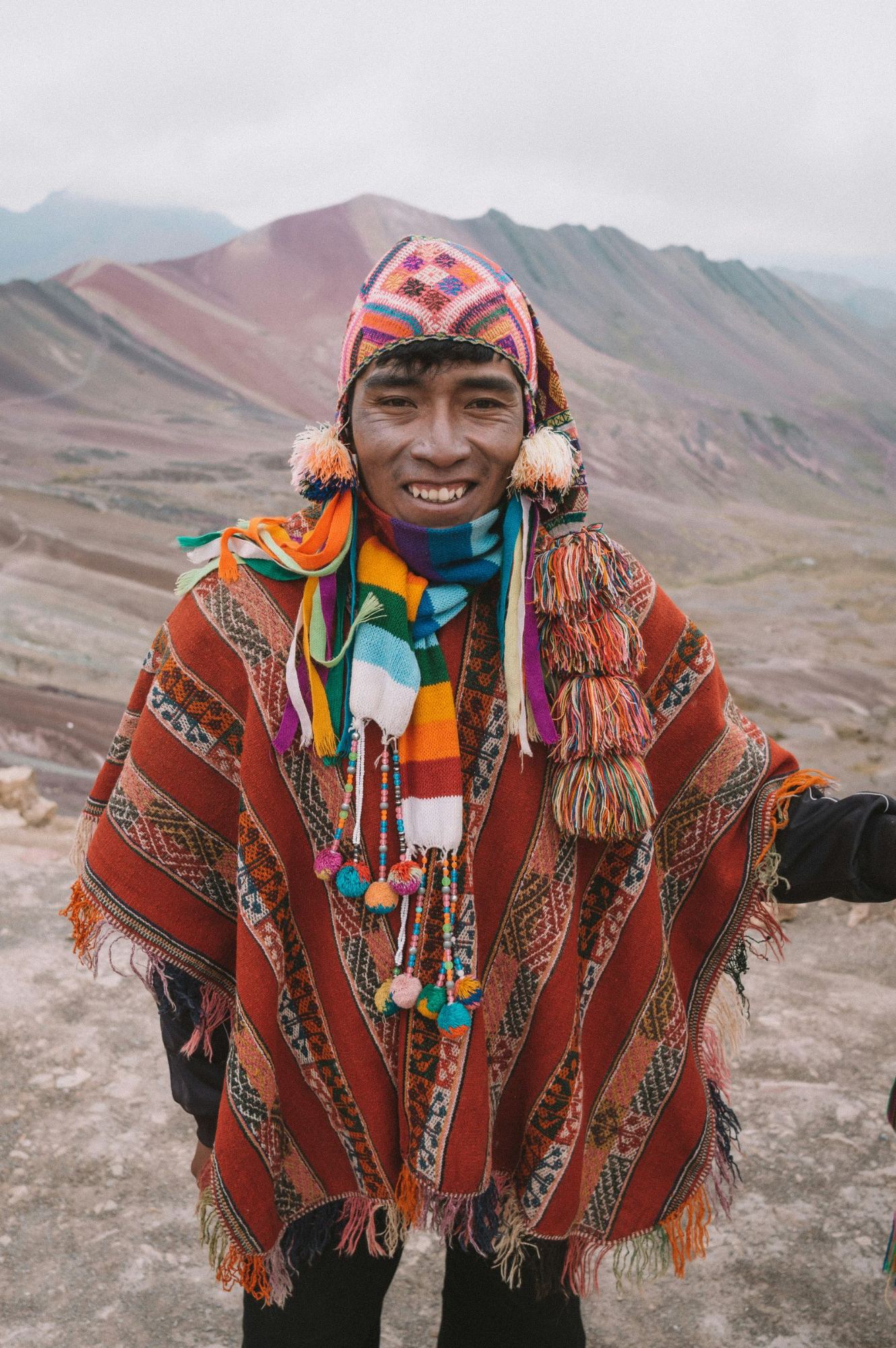 A smiling man in a woven poncho