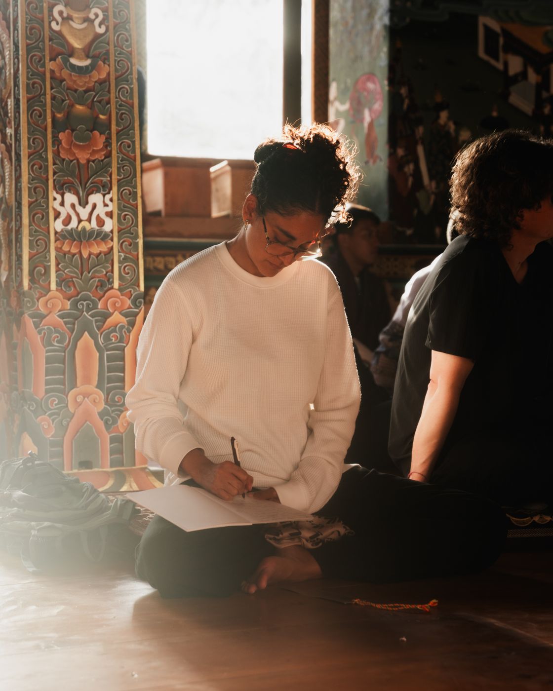 A participant writing reflections in a Bhutanese temple