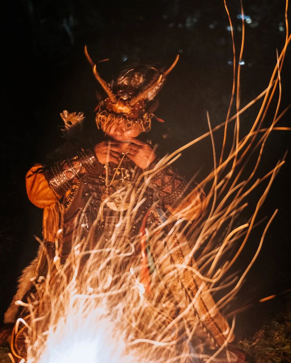 A shaman behind the sparks of the fire