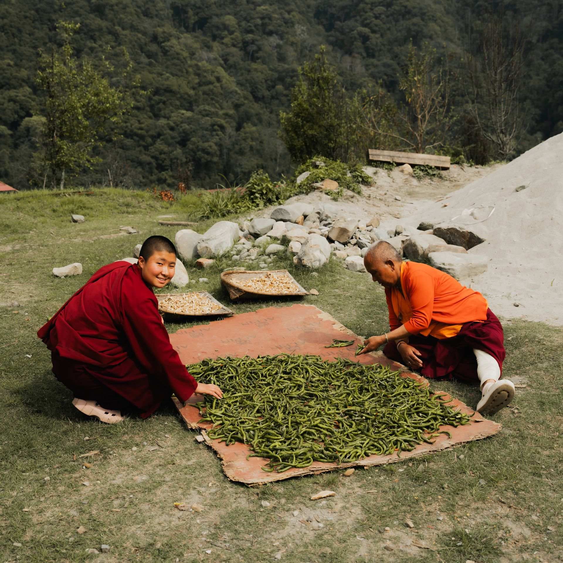 A nun and an elder drying chilies in Zhemgang
