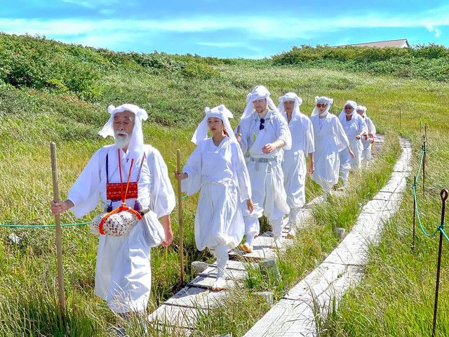Yamabushi walking a forest trail in white