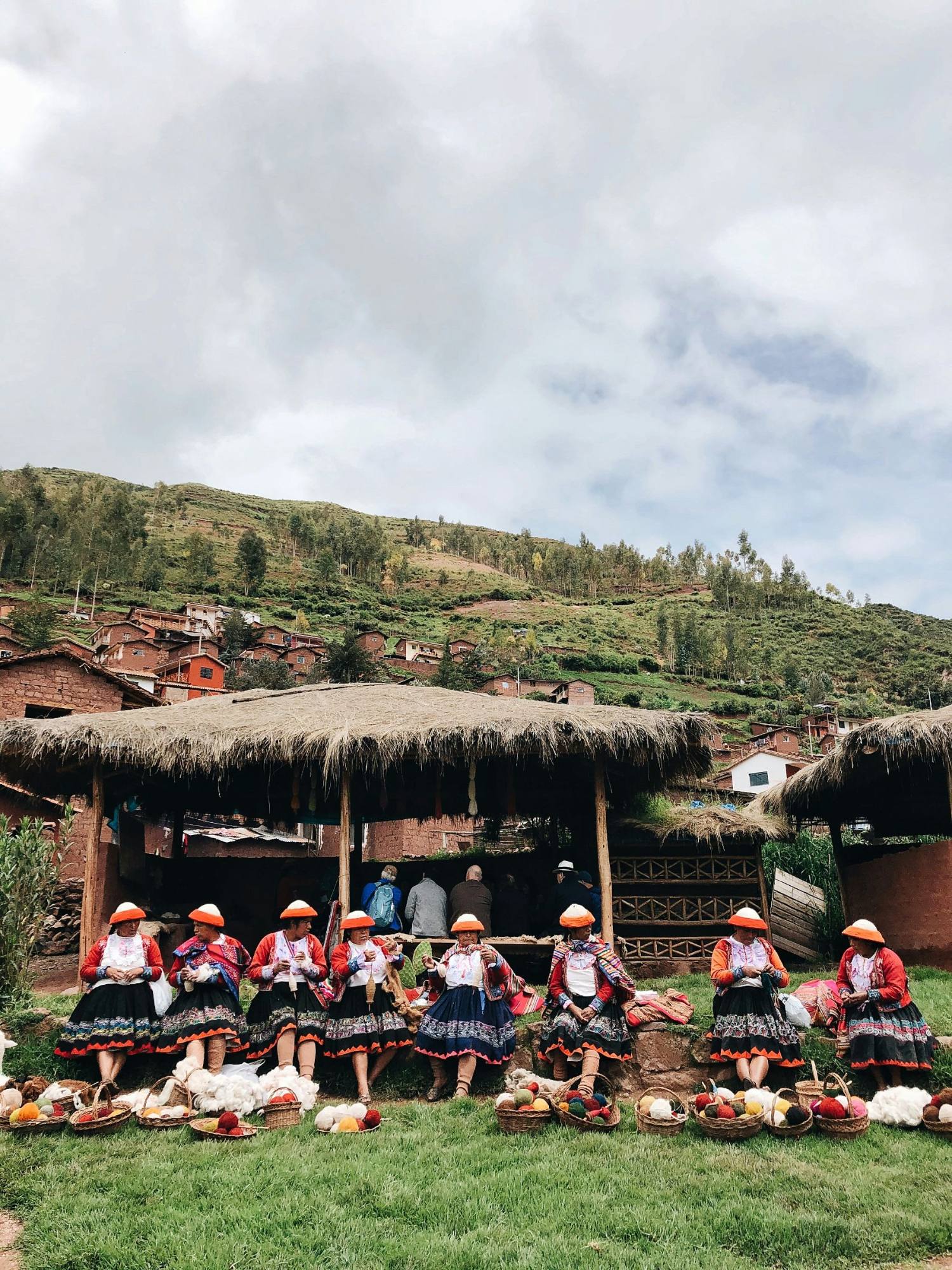 Weavers seated in a row with baskets of yarn