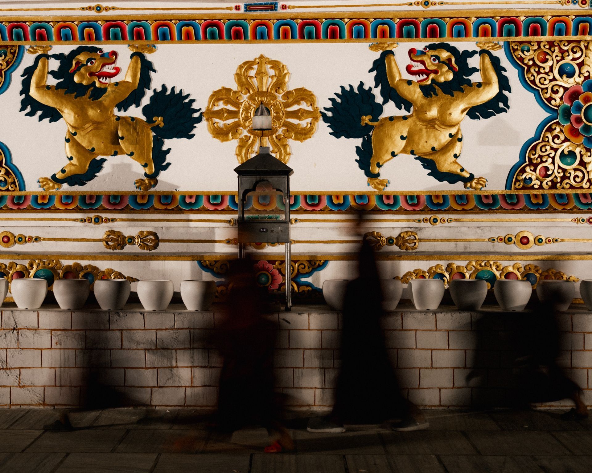 Pilgrims walking the kora beside a temple wall at night