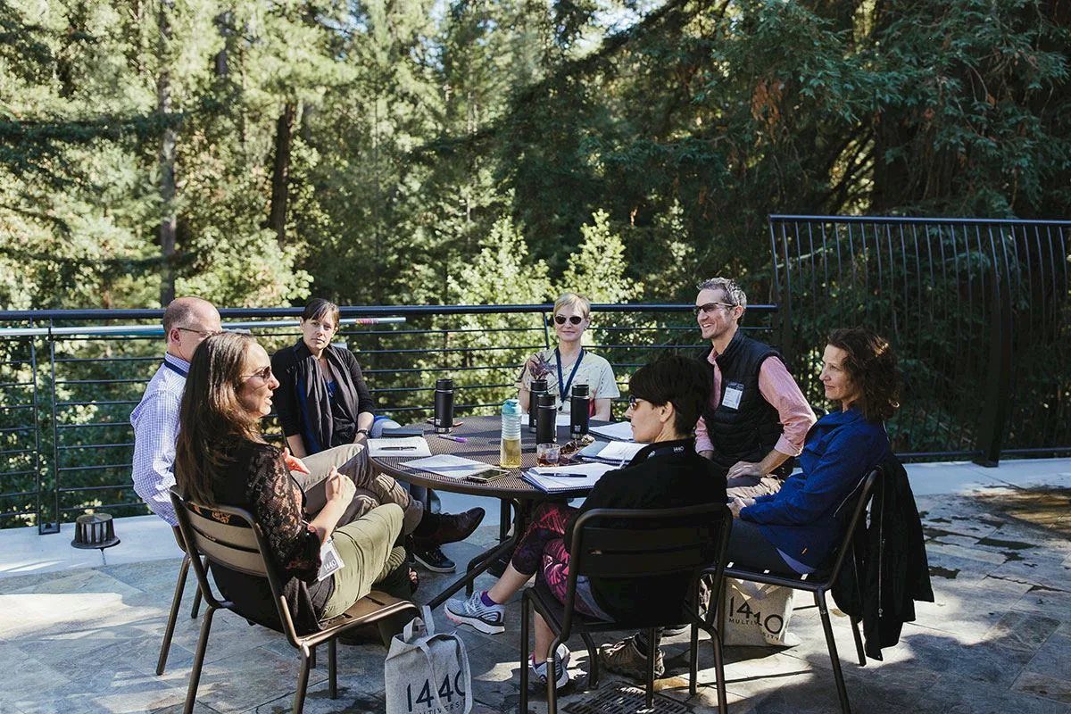 A group gathered around a long table at 1440 Multiversity